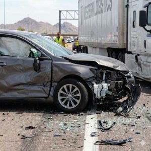 Damaged passenger vehicle after a collision with a commercial truck in Phoenix